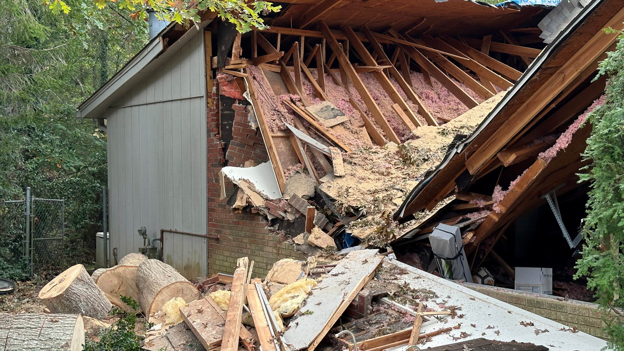 A damaged garage, caved in after a tree fell on it during the remnants of Hurricane Helene, is shown Friday, Oct. 4, 2024, in the Oak Forest neighborhood of Asheville, N.C. (AP Photo/Jeff Amy)