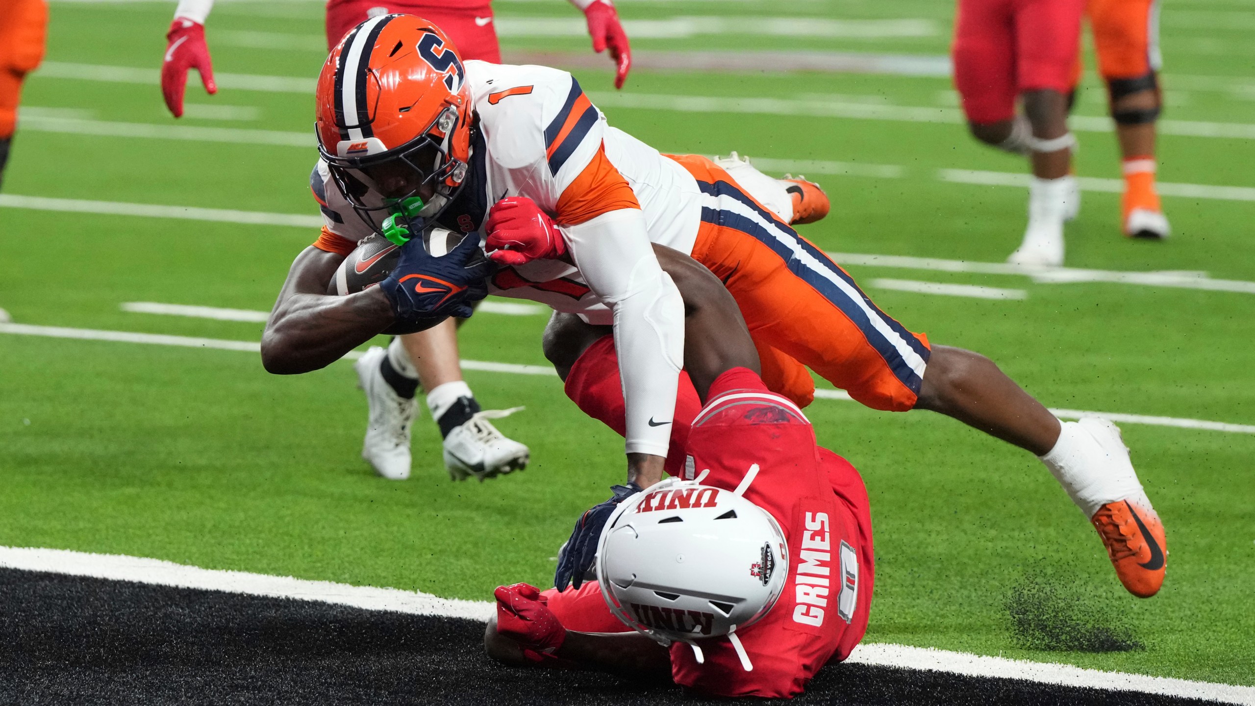 Syracuse running back LeQuint Allen (1) scores a touchdown over UNLV defensive back Tony Grimes, bottom, in the first half during an NCAA college football game, Friday, Oct. 4, 2024, in Las Vegas. (AP Photo/Rick Scuteri)