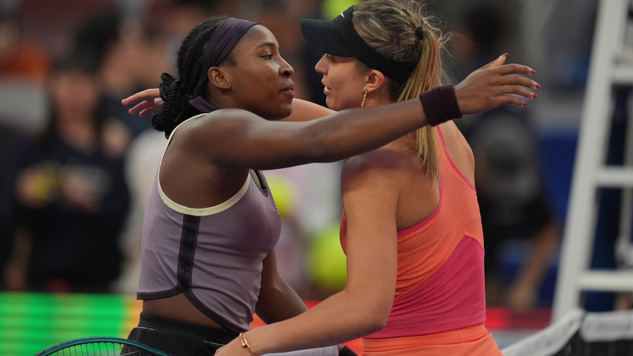 Coco Gauff of the United States left hugs Paula Badosa of Spain after their women's singles semi-final match for the China Open tennis tournament held at the National Tennis Center in Beijing, Saturday, Oct. 5, 2024. (AP Photo/Ng Han Guan)