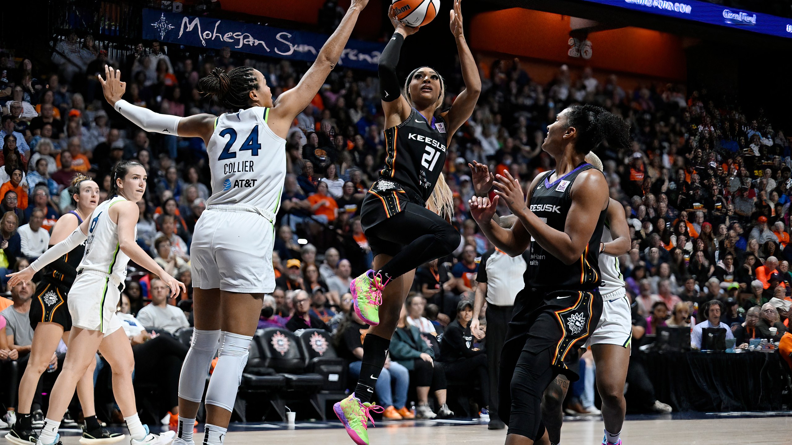 Connecticut Sun guard DiJonai Carrington (21) shoots over Minnesota Lynx forward Napheesa Collier (24) during the second half of a WNBA basketball semifinal game, Friday, Oct. 4, 2024, in Uncasville, Conn. (AP Photo/Jessica Hill)