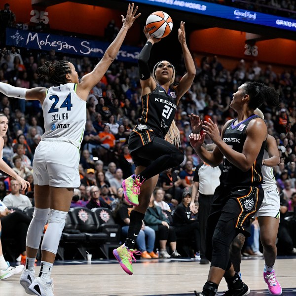 Connecticut Sun guard DiJonai Carrington (21) shoots over Minnesota Lynx forward Napheesa Collier (24) during the second half of a WNBA basketball semifinal game, Friday, Oct. 4, 2024, in Uncasville, Conn. (AP Photo/Jessica Hill)