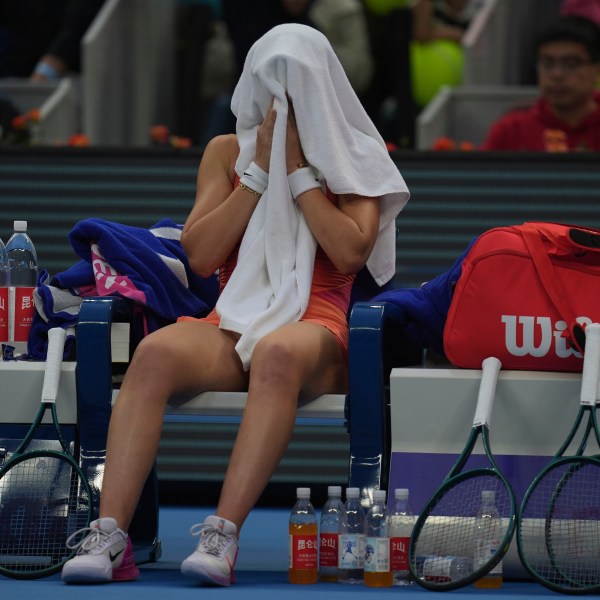 Paula Badosa of Spain cover herself with a towel during sets against Coco Gauff of the United States in a women's singles semi-final match for the China Open tennis tournament held at the National Tennis Center in Beijing, Saturday, Oct. 5, 2024. (AP Photo/Ng Han Guan)