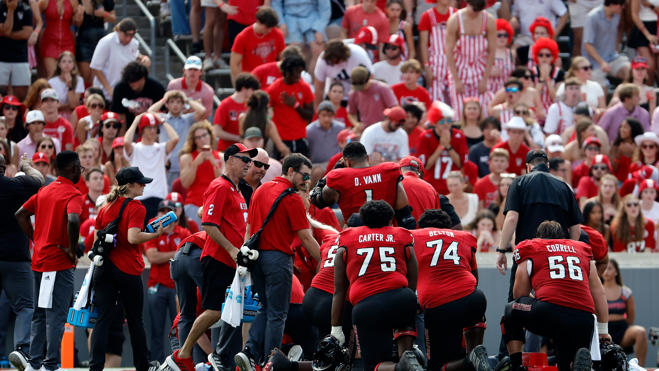 North Carolina State players take a knee as quarterback Grayson McCall (2) is taken from the field after suffering an injury during the first half of an NCAA college football game against Wake Forest in Raleigh, N.C., Saturday, Oct. 5, 2024. (AP Photo/Karl B DeBlaker)