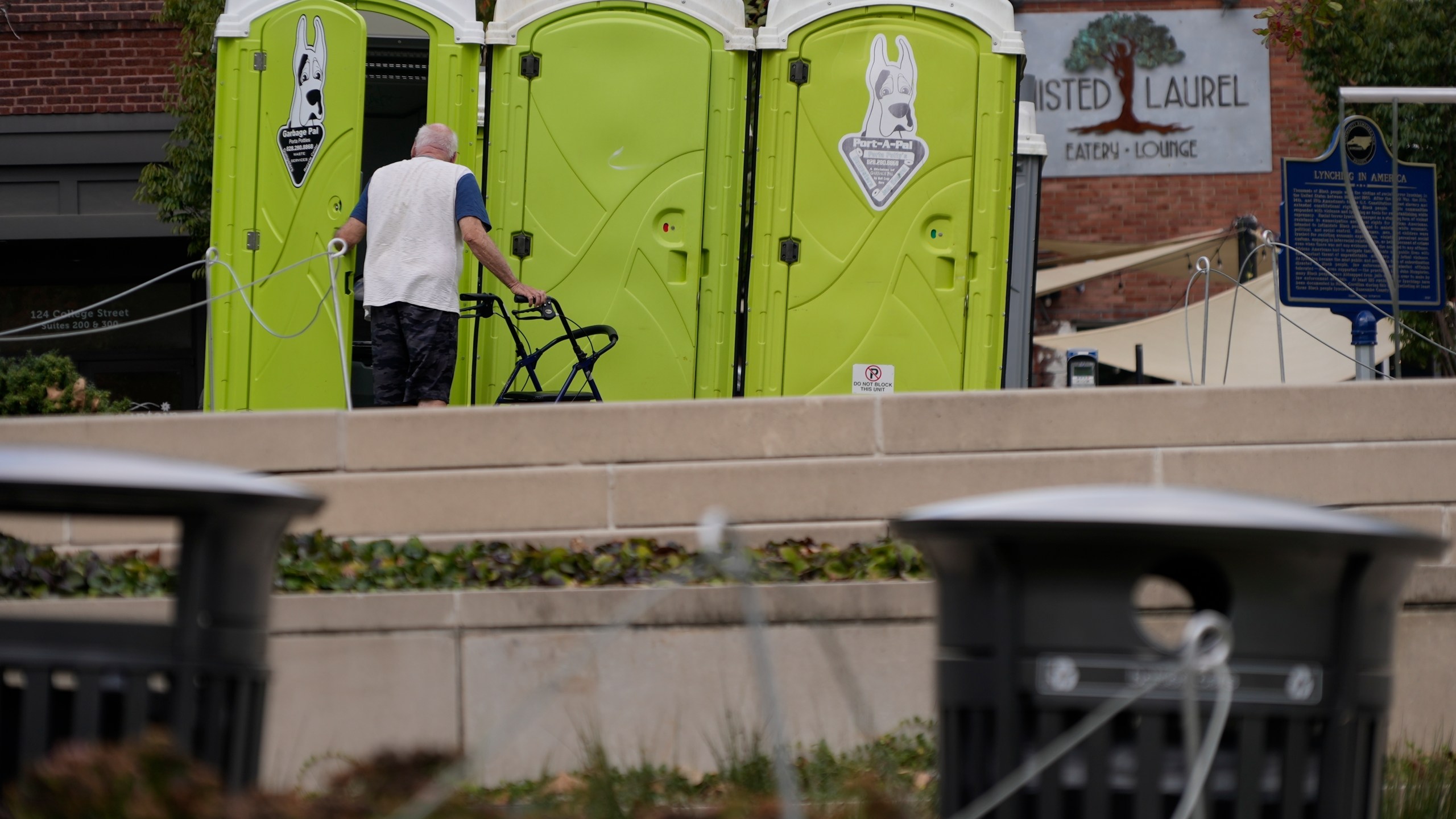 People use public toilets where there has been no water for the week since Hurricane Helene struck the region and damaged critical infrastructure, Thursday, Oct. 3, 2024 in Asheville, N.C. (AP Photo/Brittany Peterson)