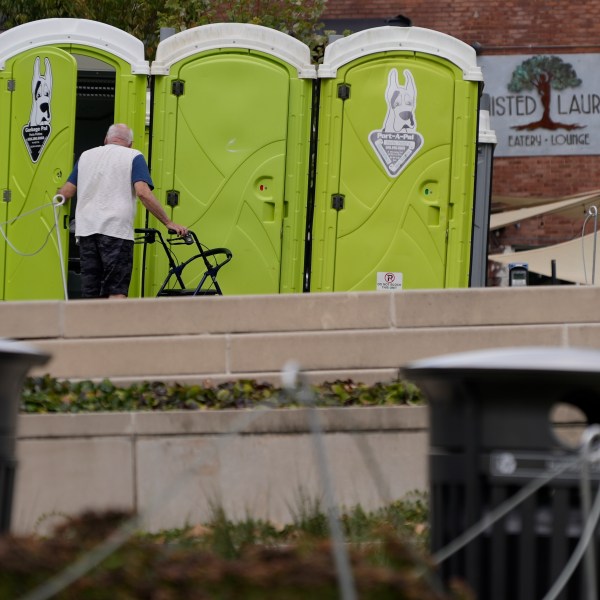 People use public toilets where there has been no water for the week since Hurricane Helene struck the region and damaged critical infrastructure, Thursday, Oct. 3, 2024 in Asheville, N.C. (AP Photo/Brittany Peterson)