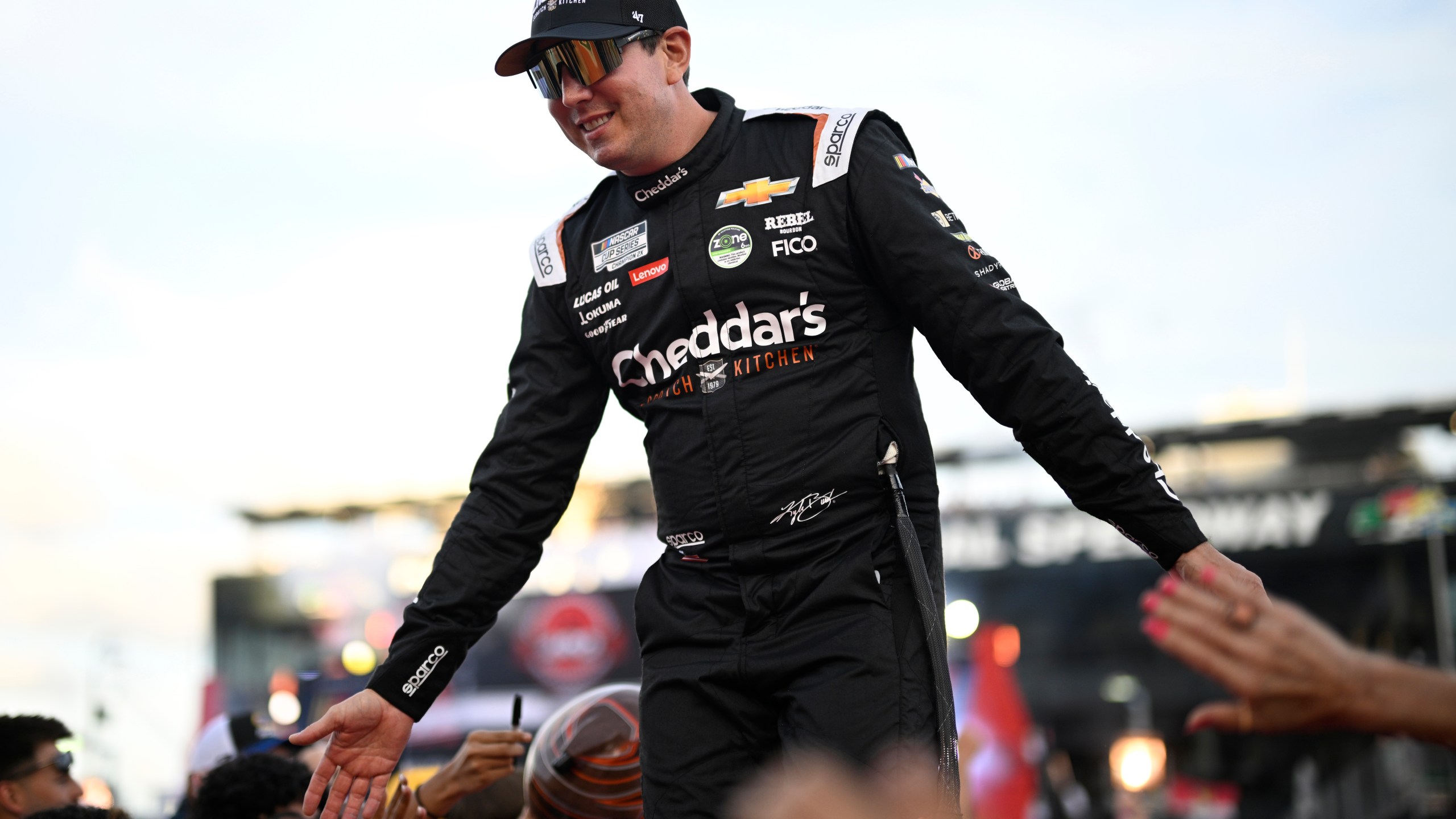 FILE - Kyle Busch interacts with spectators while walking down a runway during driver introductions before a NASCAR Cup Series auto race at Daytona International Speedway, Aug. 24, 2024, in Daytona Beach, Fla. (AP Photo/Phelan M. Ebenhack, File)