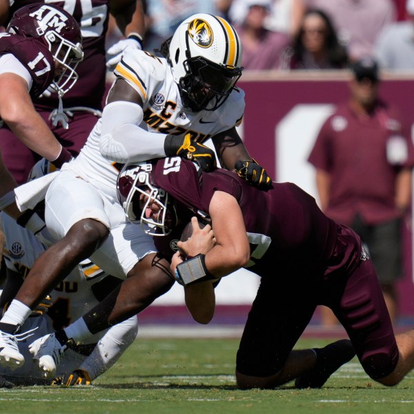 Texas A&M quarterback Conner Weigman, right, is stopped on a run by Missouri defensive end Johnny Walker Jr., left, during the first half of an NCAA college football game Saturday, Oct. 5, 2024, in College Station, Texas. (AP Photo/Eric Gay)