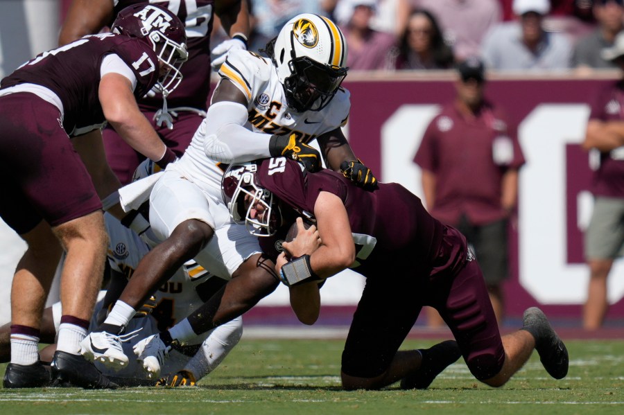 Texas A&M quarterback Conner Weigman, right, is stopped on a run by Missouri defensive end Johnny Walker Jr., left, during the first half of an NCAA college football game Saturday, Oct. 5, 2024, in College Station, Texas. (AP Photo/Eric Gay)