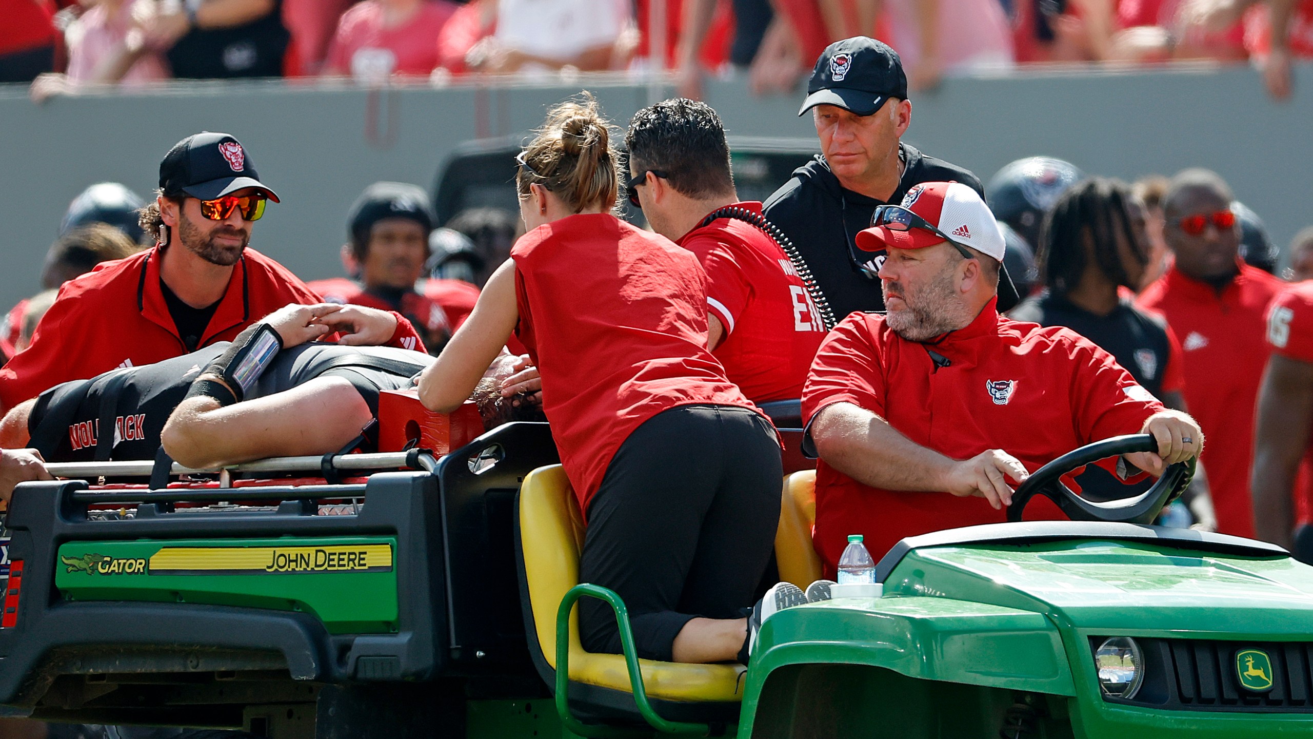 North Carolina State head coach Dave Doeren, rear right, checks on quarterback Grayson McCall (2) as he is carted from the field following an injury during the first half of an NCAA college football game in Raleigh, N.C., Saturday, Oct. 5, 2024. (AP Photo/Karl B DeBlaker)