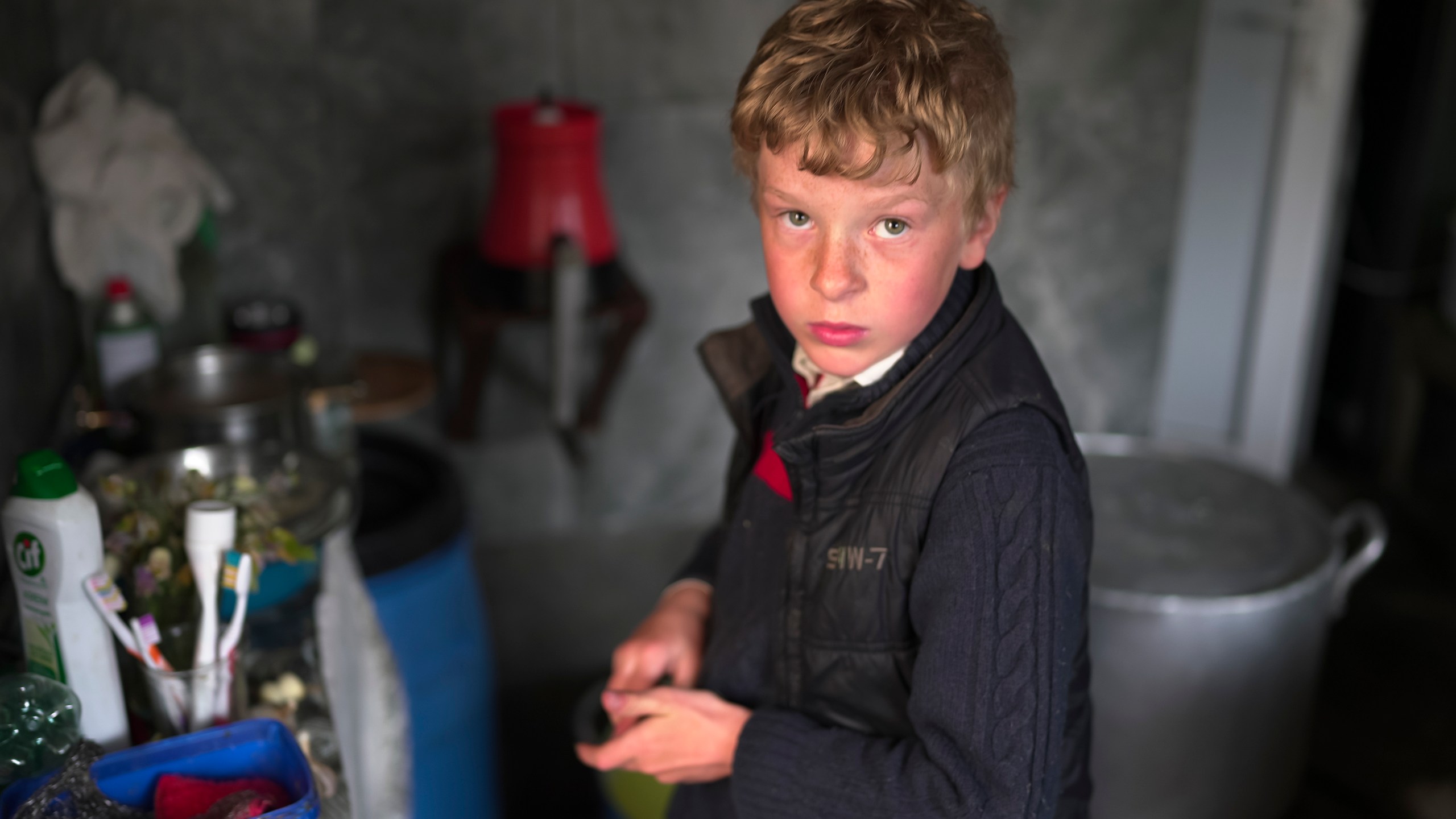 Ilya Strukov, 10, looks on in the kitchen as his family cooks dinner in their house in the remote mountain village of Orlovka, Georgia, Sunday, May 5, 2024. (AP Photo/Kostya Manenkov)