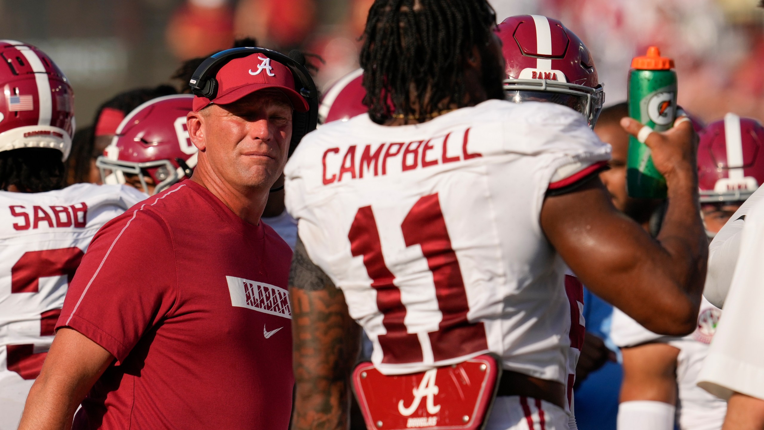 Alabama head coach Kalen DeBoer, left, talks to linebacker Jihaad Campbell (11) during the first half of an NCAA college football game against Vanderbilt, Saturday, Oct. 5, 2024, in Nashville, Tenn. (AP Photo/George Walker IV)