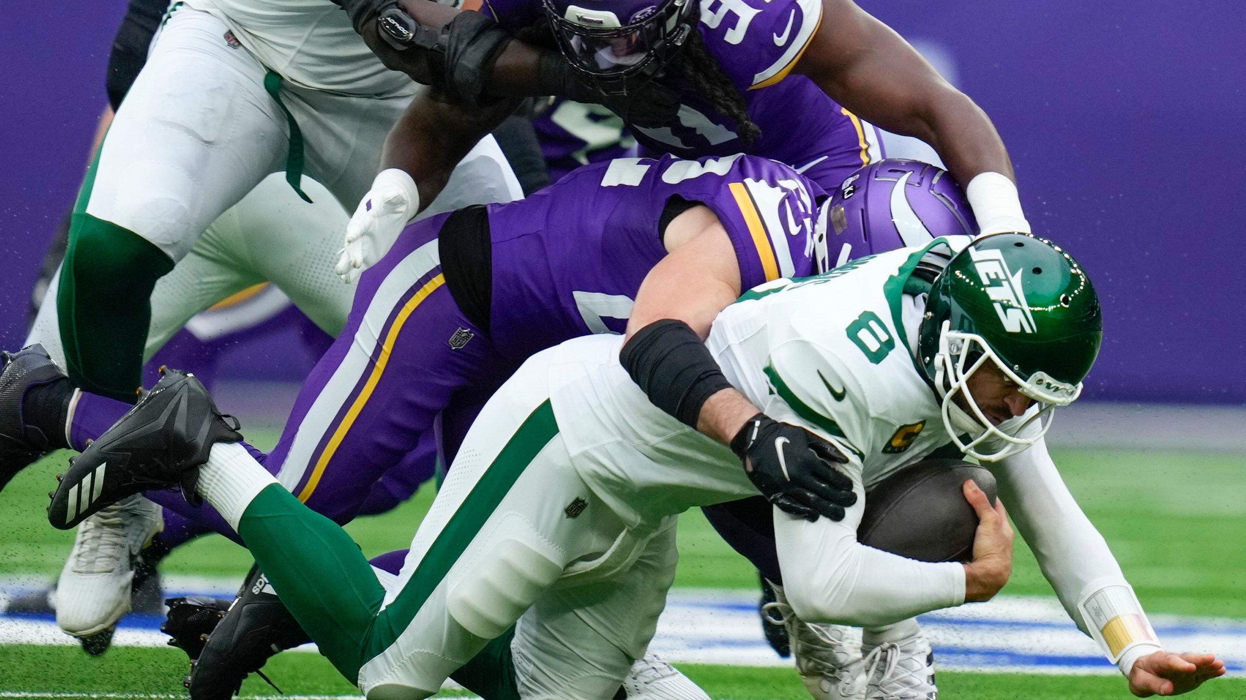 New York Jets quarterback Aaron Rodgers, bottom, is sacked by Minnesota Vikings' Harrison Smith during the first half of an NFL football game, Sunday, Oct. 6, 2024, at the Tottenham Hotspur stadium in London. (AP Photo/Kirsty Wigglesworth)