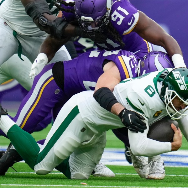 New York Jets quarterback Aaron Rodgers, bottom, is sacked by Minnesota Vikings' Harrison Smith during the first half of an NFL football game, Sunday, Oct. 6, 2024, at the Tottenham Hotspur stadium in London. (AP Photo/Kirsty Wigglesworth)