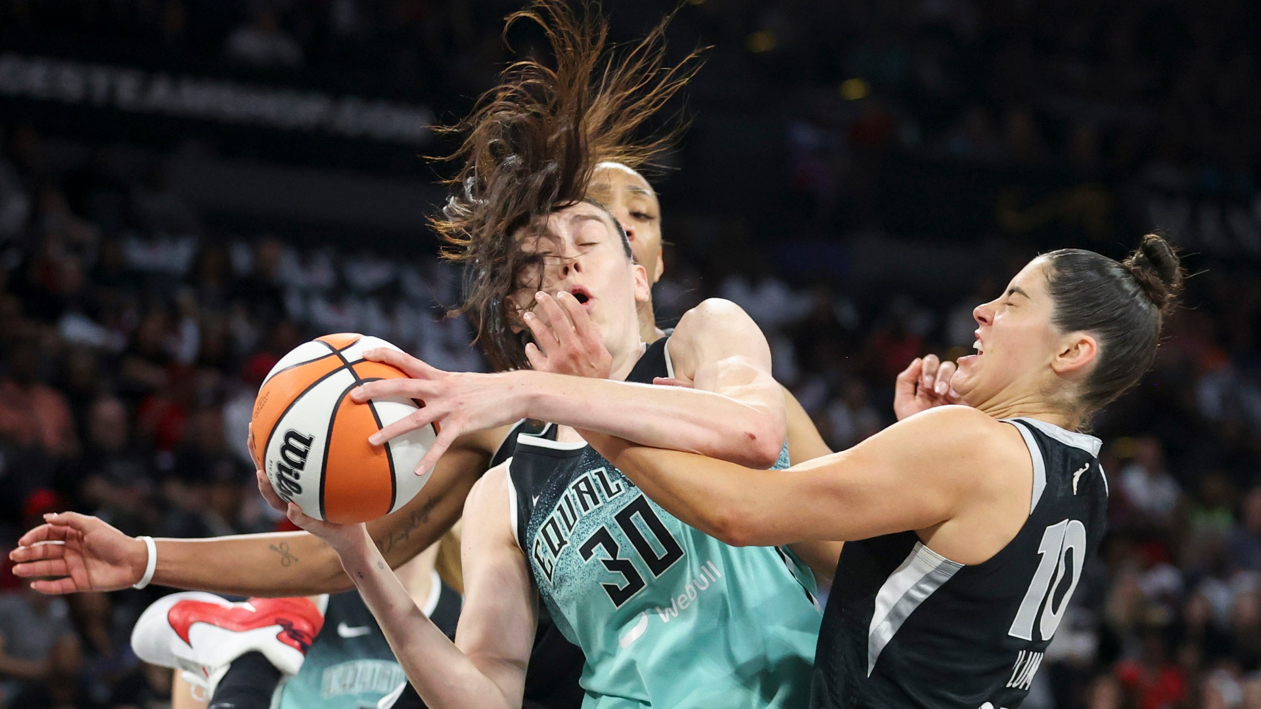 New York Liberty forward Breanna Stewart (30) grabs a rebound over Las Vegas Aces center A'ja Wilson and guard Kelsey Plum during the first half of a WNBA Semifinal basketball game, Sunday, Oct. 6, 2024, in Las Vegas. (AP Photo/Ian Maule)