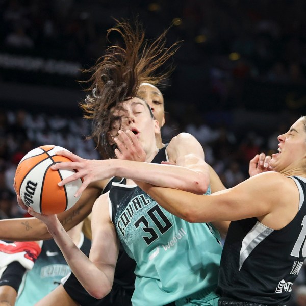 New York Liberty forward Breanna Stewart (30) grabs a rebound over Las Vegas Aces center A'ja Wilson and guard Kelsey Plum during the first half of a WNBA Semifinal basketball game, Sunday, Oct. 6, 2024, in Las Vegas. (AP Photo/Ian Maule)