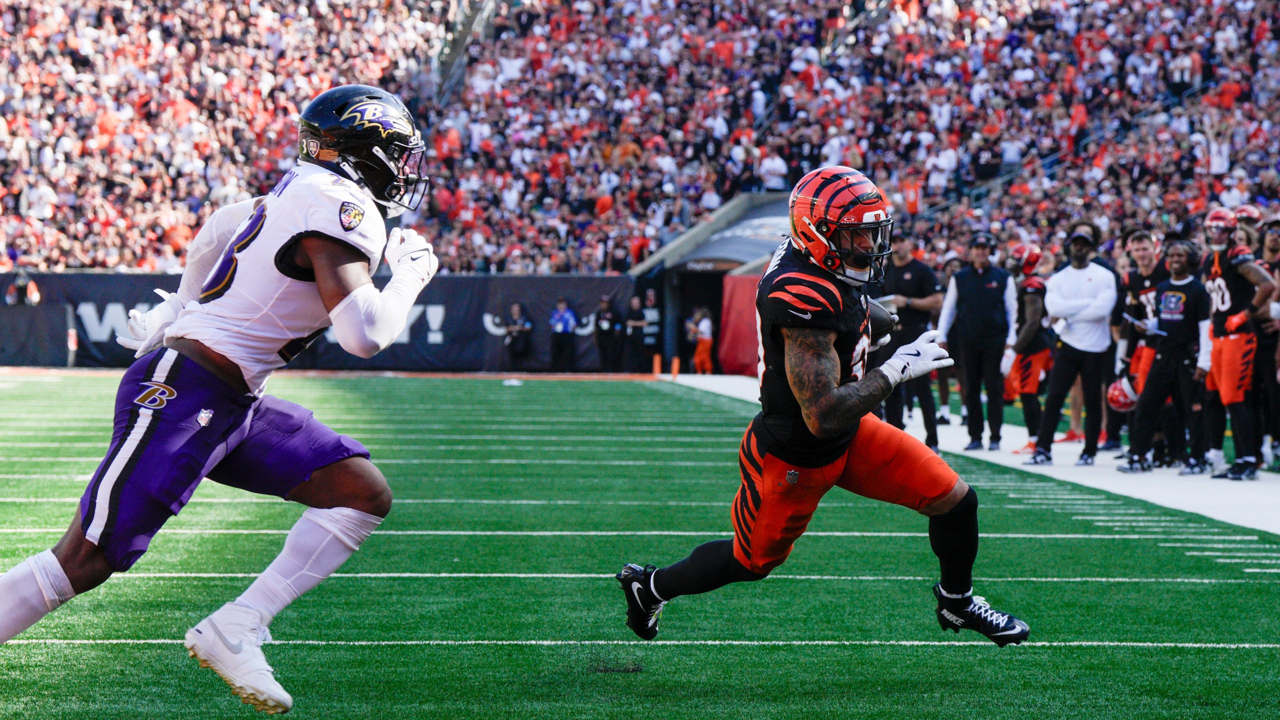 Cincinnati Bengals running back Chase Brown, right, runs in a touchdown after making a catch in front of Baltimore Ravens linebacker Trenton Simpson during the second half of an NFL football game, Sunday, Oct. 6, 2024, in Cincinnati. (AP Photo/Jeff Dean)