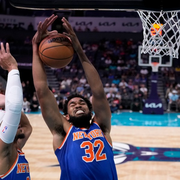 New York Knicks center Karl-Anthony Towns pulls down a rebound as guard Josh Hart looks on during the first half of a preseason NBA basketball game against the Charlotte Hornets, Sunday, Oct. 6, 2024, in Charlotte, N.C. (AP Photo/Chris Carlson)