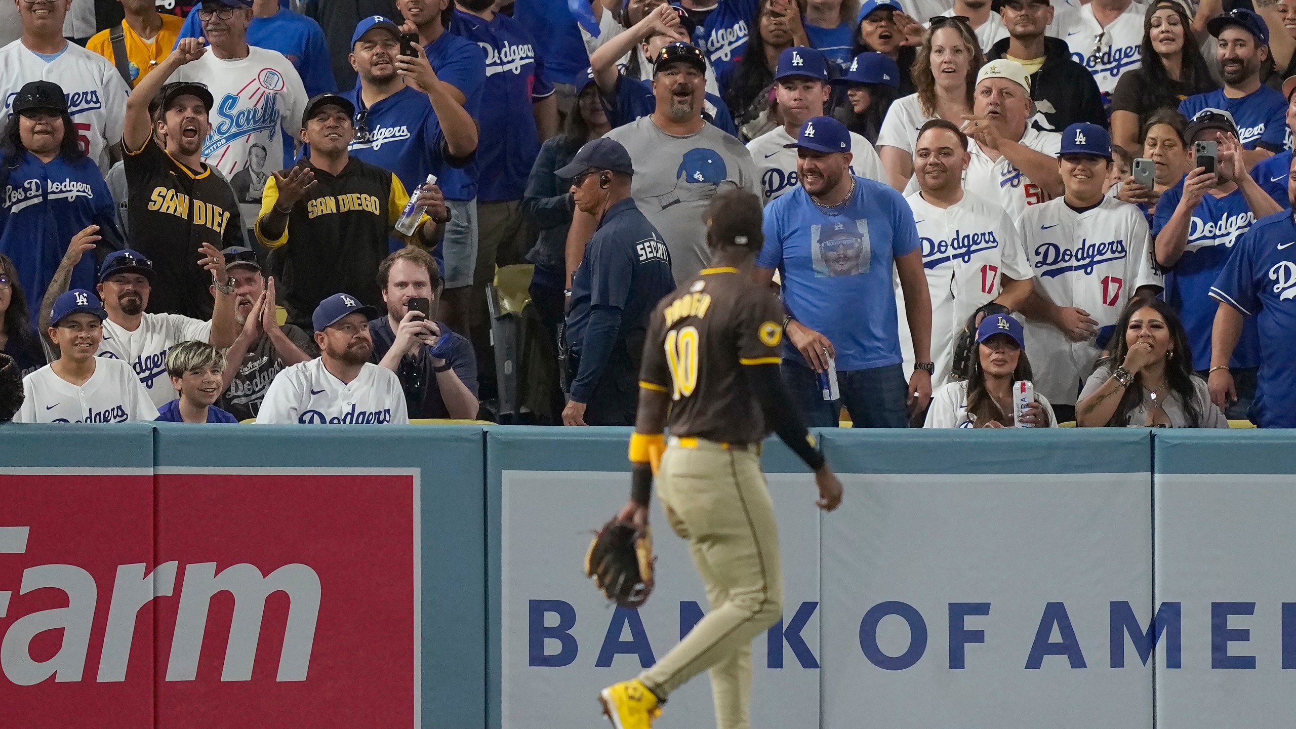 Fans react toward San Diego Padres left fielder Jurickson Profar, foreground, after items were thrown at him in the outfield during the seventh inning in Game 2 of a baseball NL Division Series between the Los Angeles Dodgers and the Padres, Sunday, Oct. 6, 2024, in Los Angeles. (AP Photo/Mark J. Terrill)