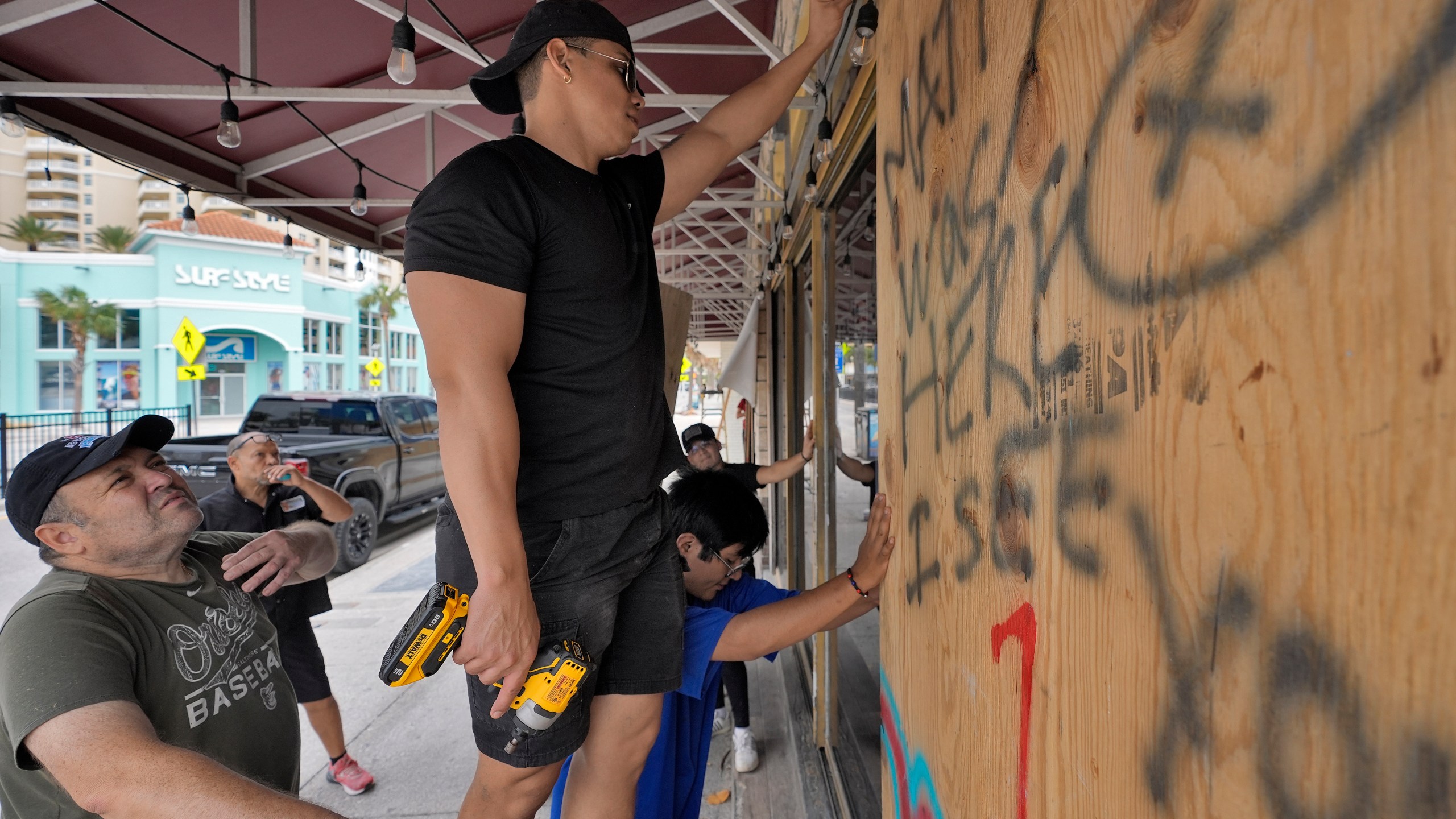 Workers outside Toucans Bar and Grill board up the restaurant Monday, Oct. 7, 2024, in Clearwater Beach, Fla., ahead of the possible arrival of Hurricane Milton. (AP Photo/Chris O'Meara)