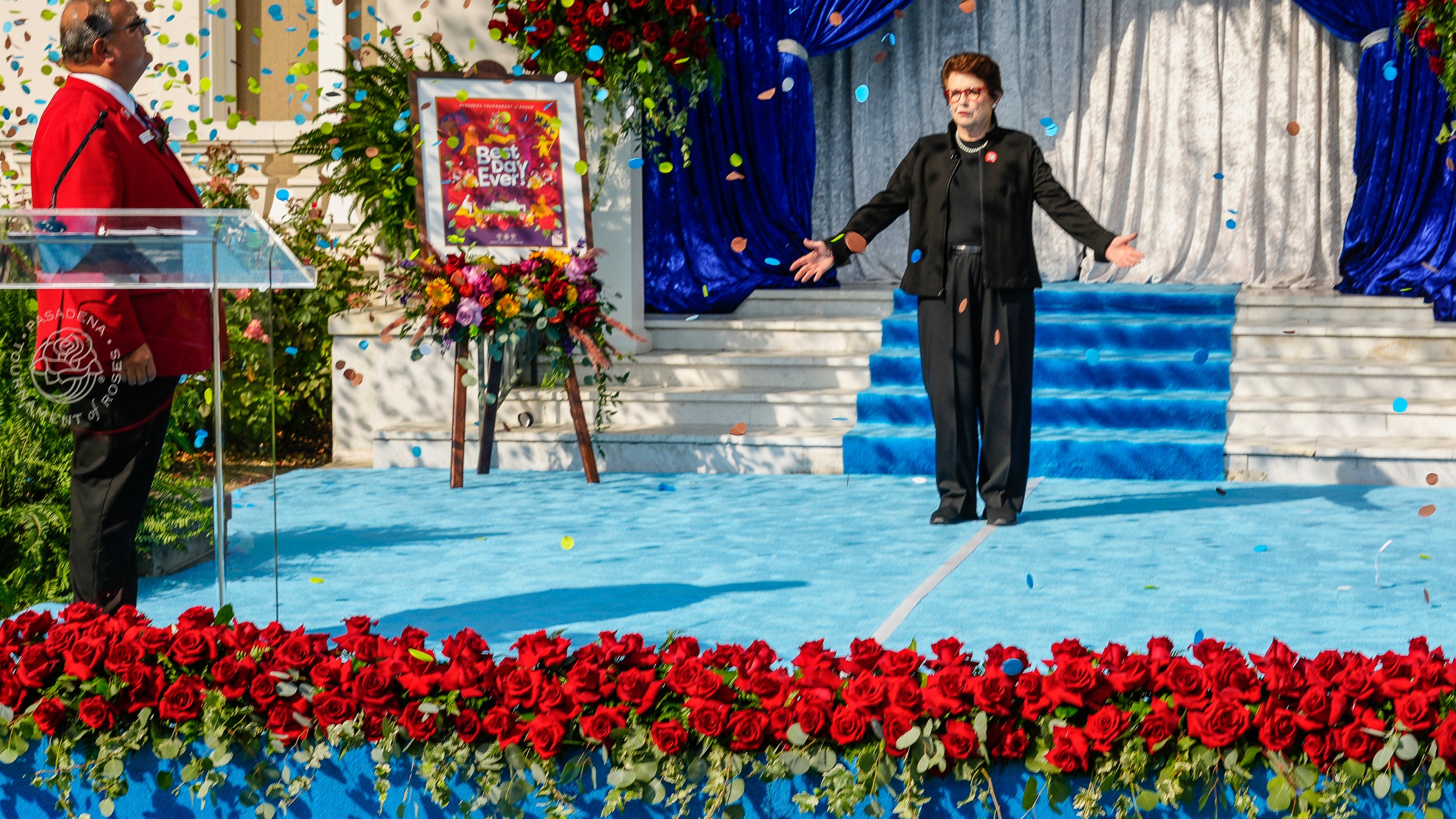 Tennis great Billie Jean King gestures as she is introduced by Roses President Ed Morales, left, as grand marshal of the 136th Rose Parade next year on the front steps of the Tournament House in Pasadena, Calif., Monday, Oct. 7, 2024. (AP Photo/Damian Dovarganes)