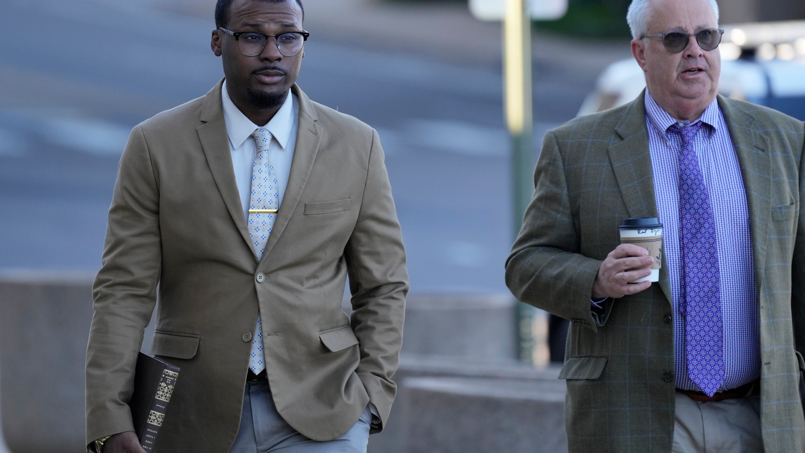 Justin Smith, left, one of three former Memphis police officers charged in the 2023 fatal beating of Tyre Nichols, arrives at the federal courthouse with his attorney Martin Zummach, right, for the day's proceedings Thursday, Oct. 3, 2024, in Memphis, Tenn. (AP Photo/George Walker IV)