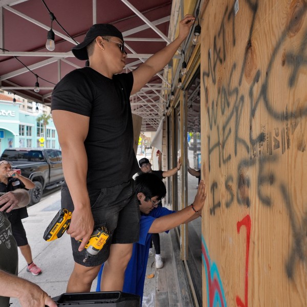 Workers outside Toucans Bar and Grill board up the restaurant Monday, Oct. 7, 2024, in Clearwater Beach, Fla., ahead of the possible arrival of Hurricane Milton. (AP Photo/Chris O'Meara)