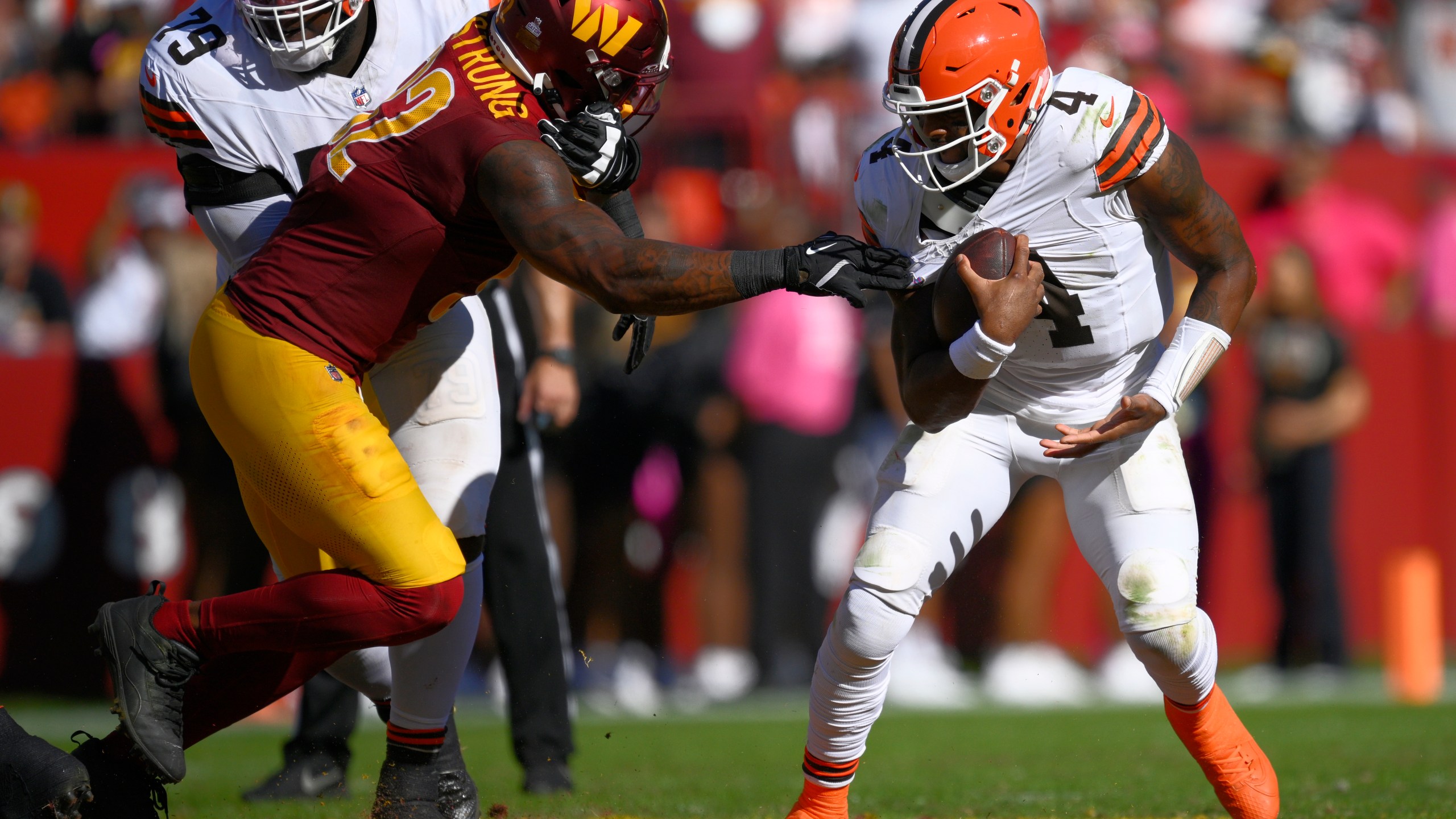 Cleveland Browns quarterback Deshaun Watson (4) break away from Washington Commanders defensive end Dorance Armstrong (92) during the second half of an NFL football game in Landover, Md., Sunday, Oct. 6, 2024. (AP Photo/Nick Wass)