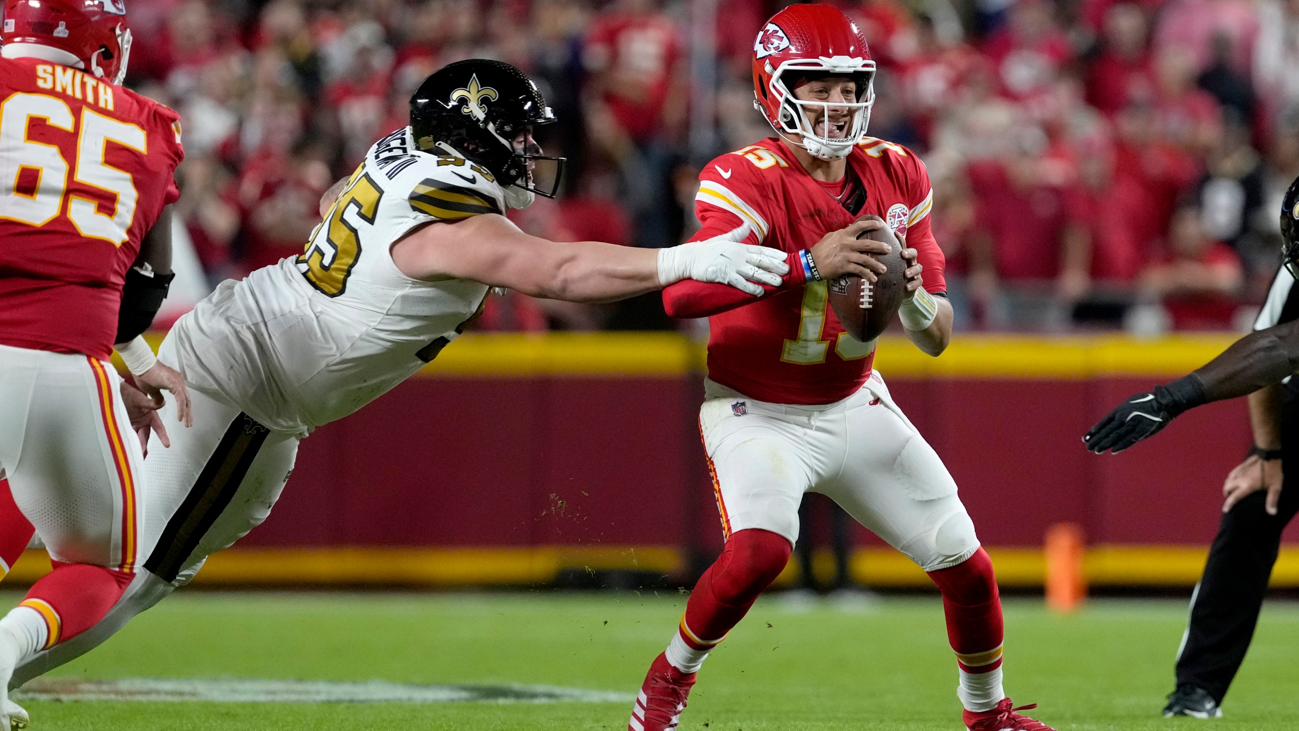 Kansas City Chiefs quarterback Patrick Mahomes, right, scrambles away from New Orleans Saints defensive tackle John Ridgeway III during the first half of an NFL football game Monday, Oct. 7, 2024, in Kansas City, Mo. (AP Photo/Ed Zurga)