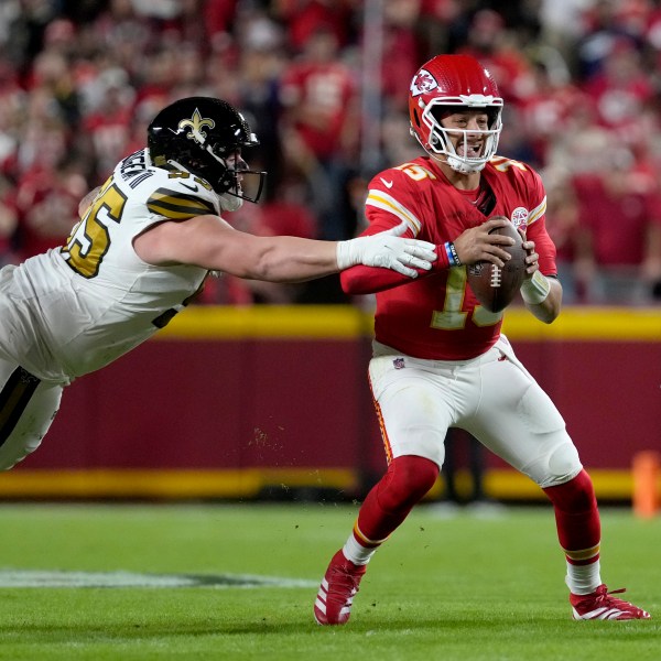 Kansas City Chiefs quarterback Patrick Mahomes, right, scrambles away from New Orleans Saints defensive tackle John Ridgeway III during the first half of an NFL football game Monday, Oct. 7, 2024, in Kansas City, Mo. (AP Photo/Ed Zurga)