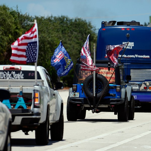 Trump supporters who turned out to protest against abortion follow the bus at the start of the "Reproductive Freedom Bus Tour" by the campaign of Democratic presidential nominee Vice President Kamala Harris and running mate Gov. Tim Walz, Tuesday, Sept. 3, 2024, in Boynton Beach, Fla. (AP Photo/Rebecca Blackwell)