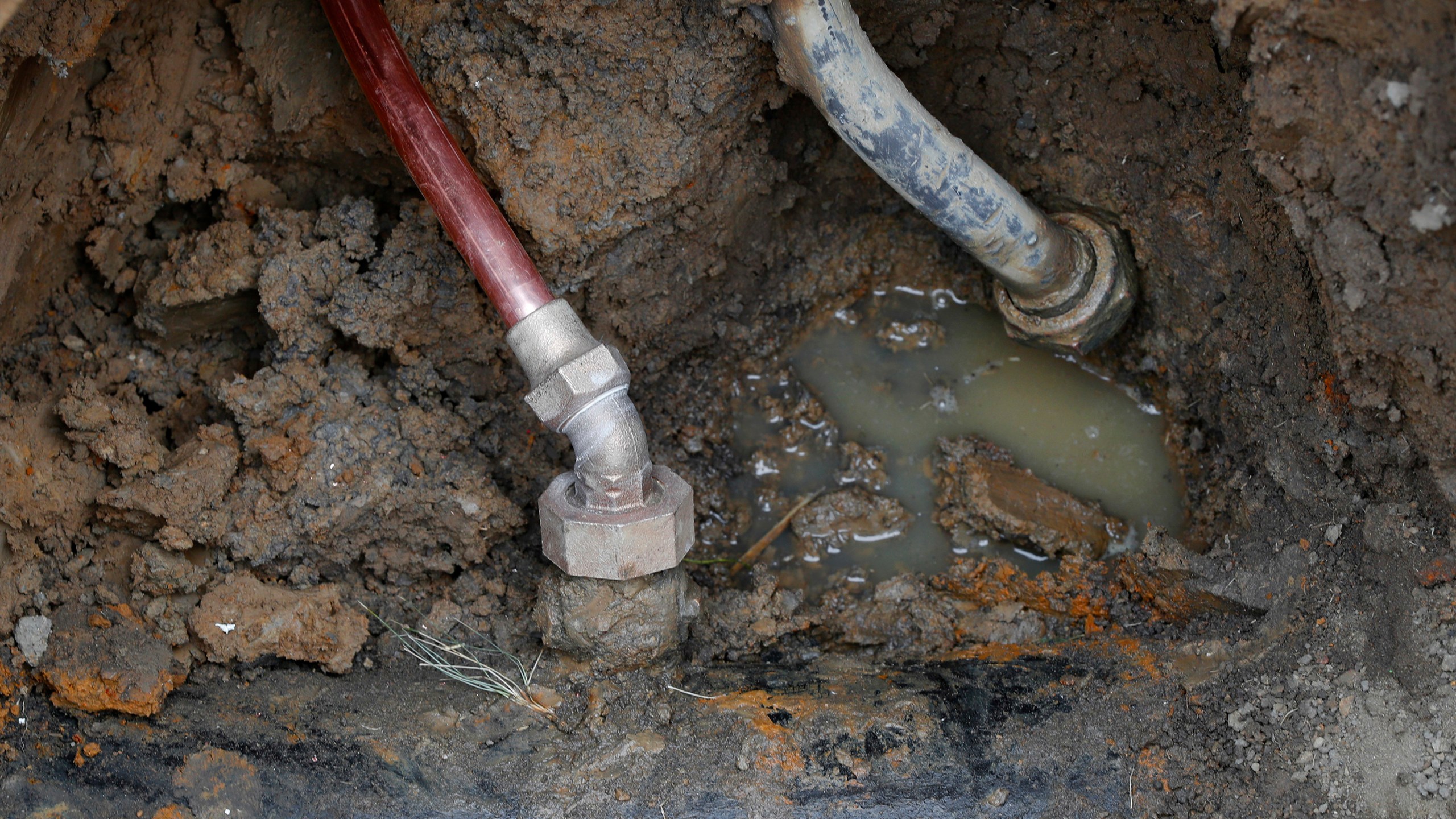 FILE - A copper water supply line, left, is shown connected to a water main after being installed for lead pipe, right, July 20, 2018, in Flint, Mich. (AP Photo/Paul Sancya, File)