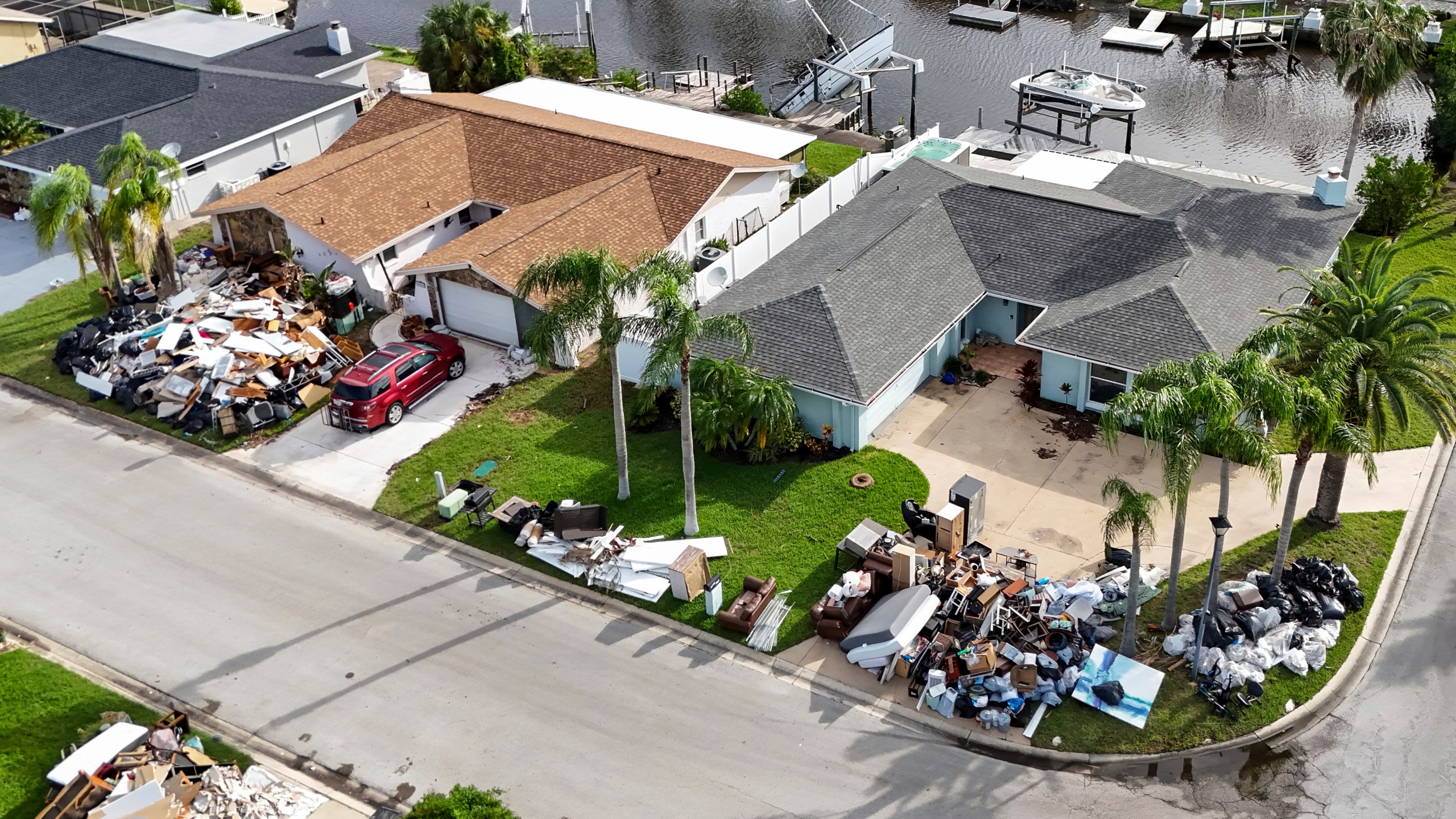 Debris from homes flooded in Hurricane Helene is piled curbside as Hurricane Milton approaches on Tuesday, Oct. 8, 2024, in Port Richey, Fla. (AP Photo/Mike Carlson)