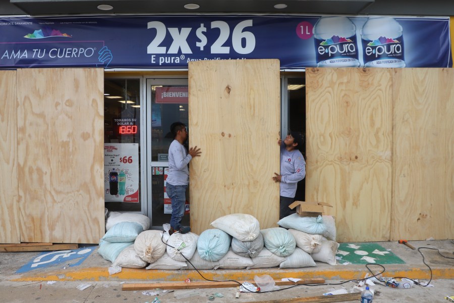 FILE - Workers board up a grocery store to protect it from Hurricane Milton, in Progreso, Yucatan state, Mexico, Oct. 7, 2024. (AP Photo/Martin Zetina, File)