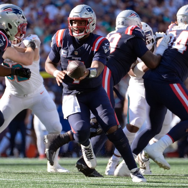 New England Patriots quarterback Jacoby Brissett, center, sets to hand off the ball against the Miami Dolphins during the second half of an NFL football game, Sunday, Oct. 6, 2024, in Foxborough, Mass. (AP Photo/Michael Dwyer)