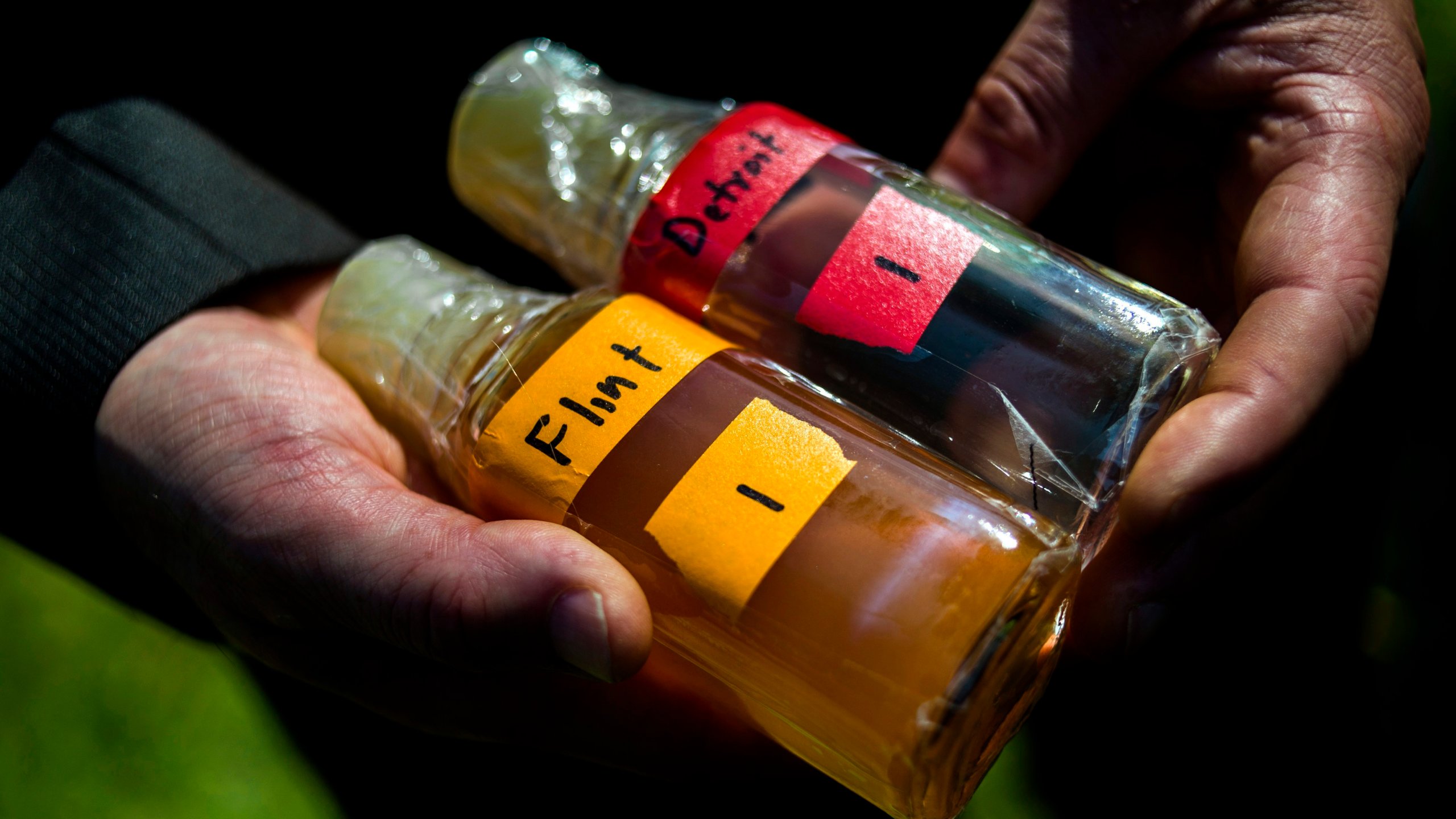 FILE - Virginia Tech professor Marc Edwards shows the difference in water quality between Detroit and Flint after testing, giving evidence after more than 270 samples were sent in from Flint that show high levels of lead during a news conference on Sept. 15, 2015, in downtown Flint, Mich. (Jake May/The Flint Journal via AP, File)