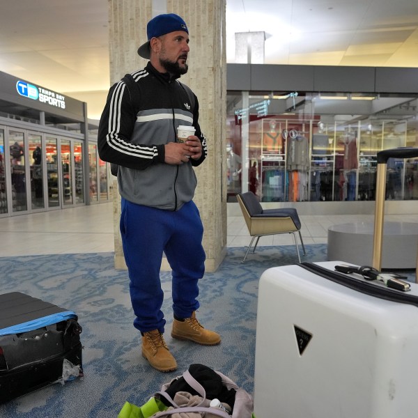 John Fedor, of New Jersey, waits for transportation help to get to a shelter after his flight was canceled Tuesday, Oct. 8, 2024, at the Tampa International Airport in Tampa, Fla., due to the possible arrival of Hurricane Milton. (AP Photo/Chris O'Meara)