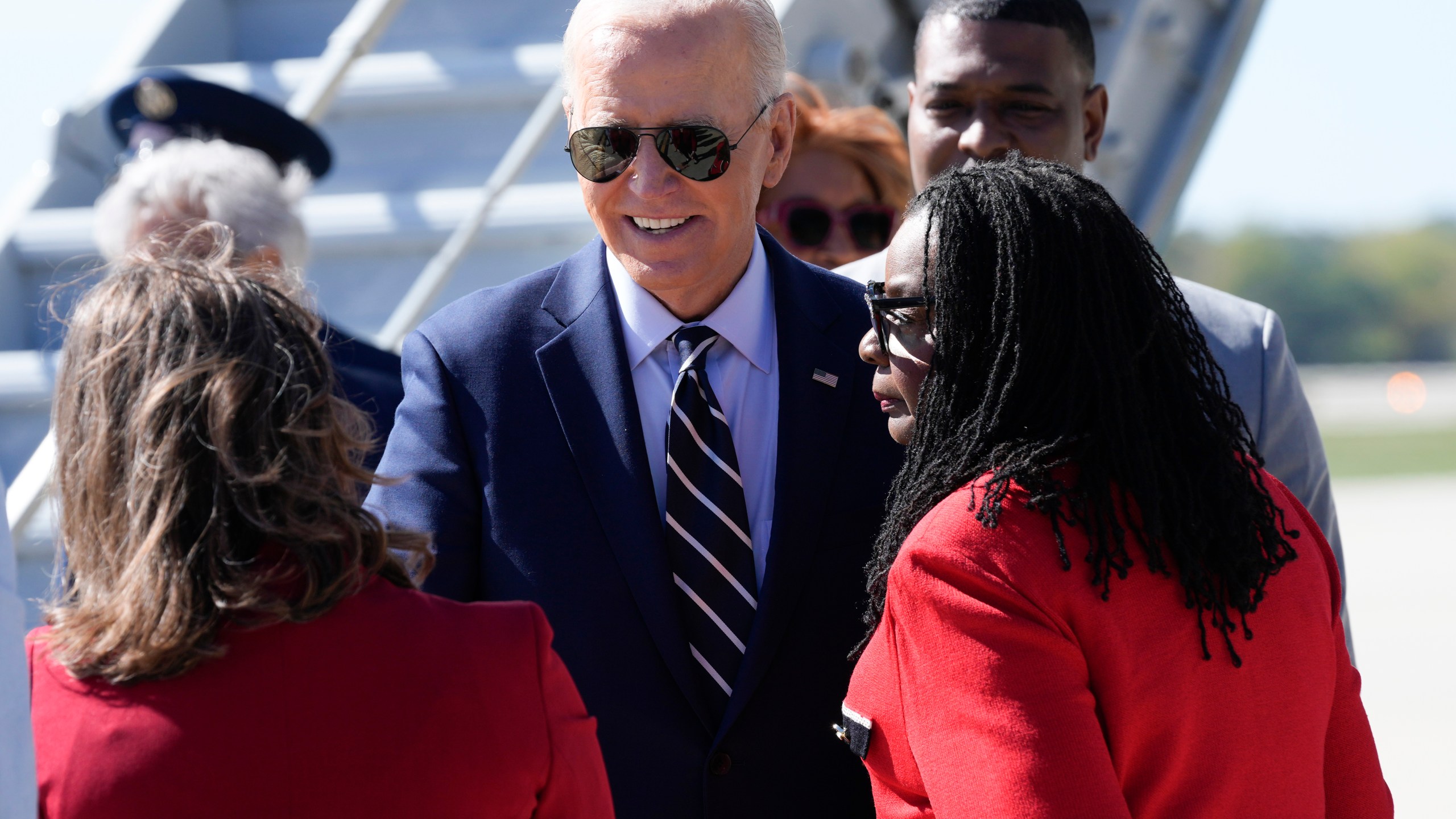 President Joe Biden is greeted by Rep. Gwen Moore, D-Wis., right, and other officials after arriving at Milwaukee Mitchell International Airport in Milwaukee, Tuesday, Oct. 8, 2024. (AP Photo/Susan Walsh)