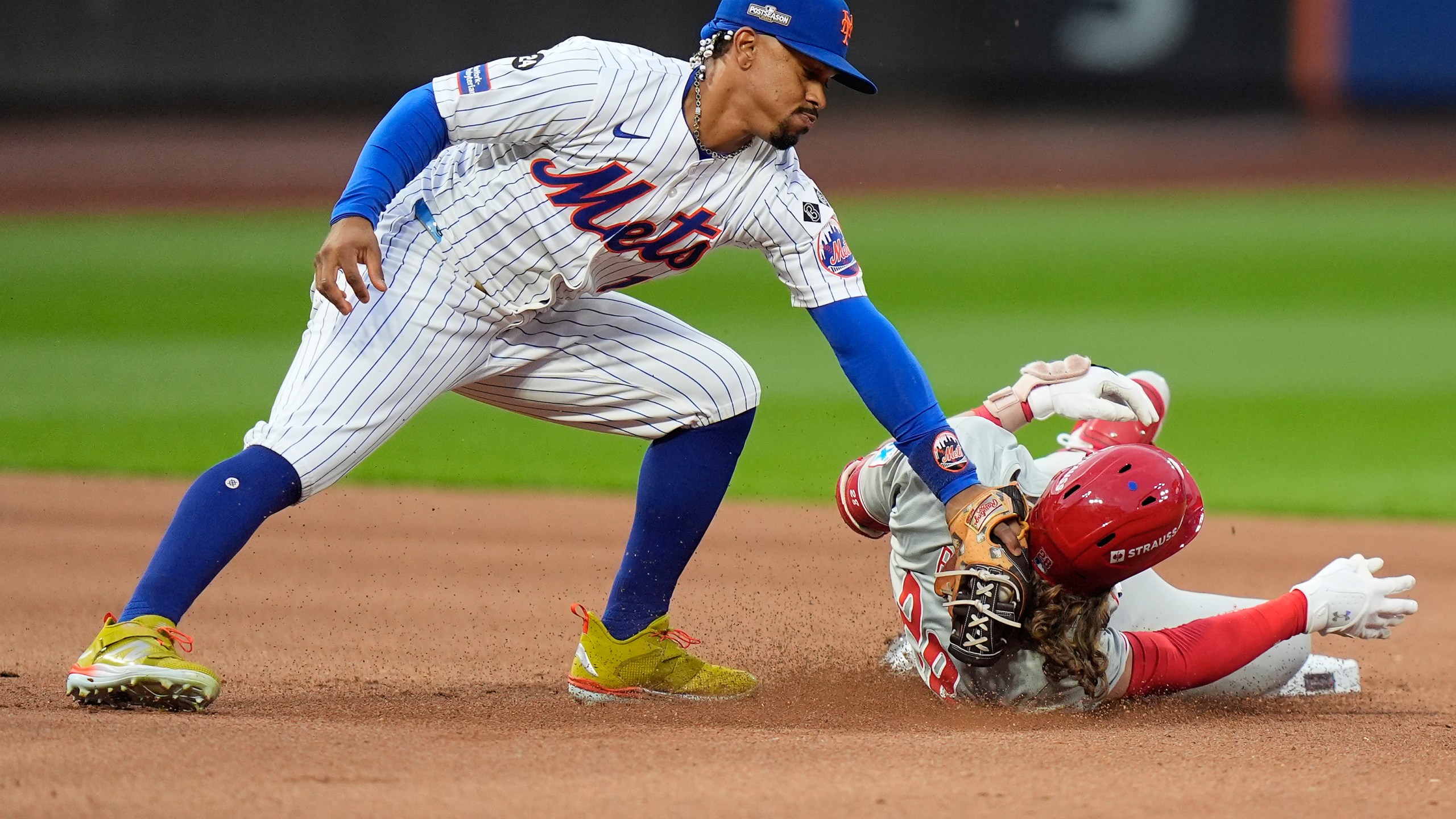 New York Mets shortstop Francisco Lindor (12) tags out Philadelphia Phillies' Alec Bohm (28) as Bohm attempts to stretch a base hit into a double during the fourth inning of Game 3 of the National League baseball playoff series, Tuesday, Oct. 8, 2024, in New York. (AP Photo/Frank Franklin II)