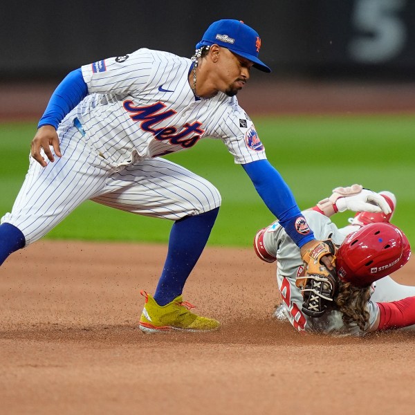 New York Mets shortstop Francisco Lindor (12) tags out Philadelphia Phillies' Alec Bohm (28) as Bohm attempts to stretch a base hit into a double during the fourth inning of Game 3 of the National League baseball playoff series, Tuesday, Oct. 8, 2024, in New York. (AP Photo/Frank Franklin II)