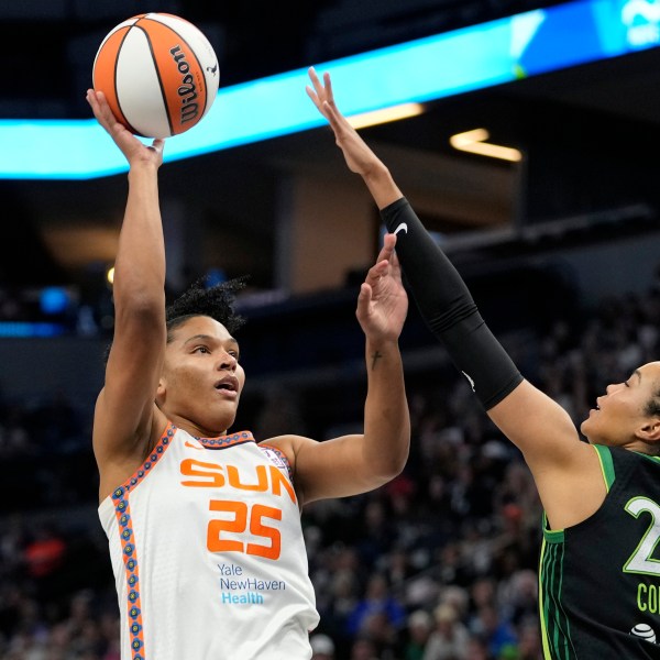 Connecticut Sun forward Alyssa Thomas (25) shoots over Minnesota Lynx forward Napheesa Collier (24) during the first half of Game 5 of a WNBA basketball semifinals, Tuesday, Oct. 8, 2024, in Minneapolis. (AP Photo/Abbie Parr)