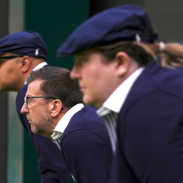 FILE - Line judges concentrate as Russia's Daniil Medvedev plays Britain's Arthur Fery in a first round men's singles match on day three of the Wimbledon tennis championships in London, Wednesday, July 5, 2023. That long-held Wimbledon tradition of line judges dressed in elegant uniforms is no more. The All England Club has announced that artificial intelligence will be used to make the 'out' and 'fault' calls at the championships from 2025. (AP Photo/Alberto Pezzali, File)