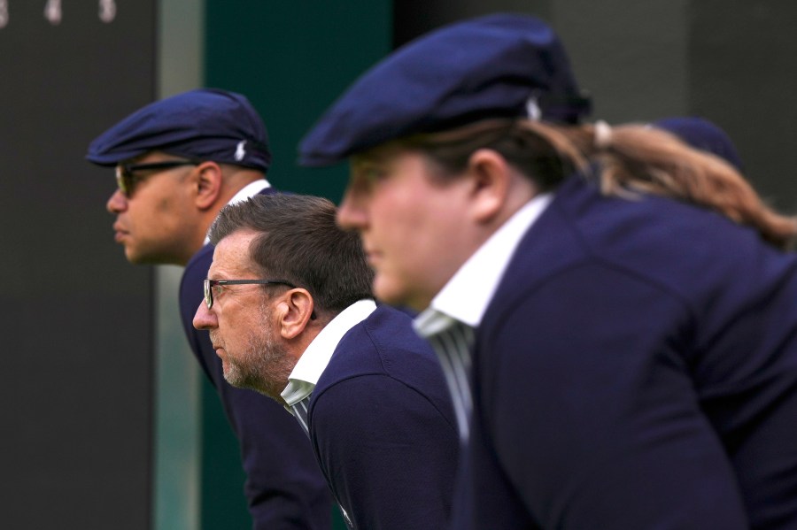 FILE - Line judges concentrate as Russia's Daniil Medvedev plays Britain's Arthur Fery in a first round men's singles match on day three of the Wimbledon tennis championships in London, Wednesday, July 5, 2023. That long-held Wimbledon tradition of line judges dressed in elegant uniforms is no more. The All England Club has announced that artificial intelligence will be used to make the 'out' and 'fault' calls at the championships from 2025. (AP Photo/Alberto Pezzali, File)