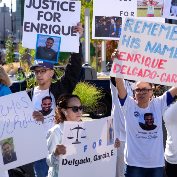 People display signs with with a likeness of Massachusetts State Police recruit Enrique Delgado-Garcia, who died following a State Police Academy training exercise, at a protest outside the State Police Academy graduation ceremony, Wednesday, Oct. 9, 2024, at the DCU Center, in Worcester, Mass. (AP Photo/Steven Senne)