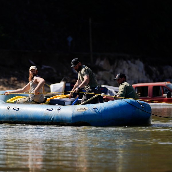 Civilian volunteers using an inflatable raft deliver supplies to residents in the aftermath of Hurricane Helene, Tuesday, Oct. 8, 2024, in Burnsville, N.C. (AP Photo/Erik Verduzco)