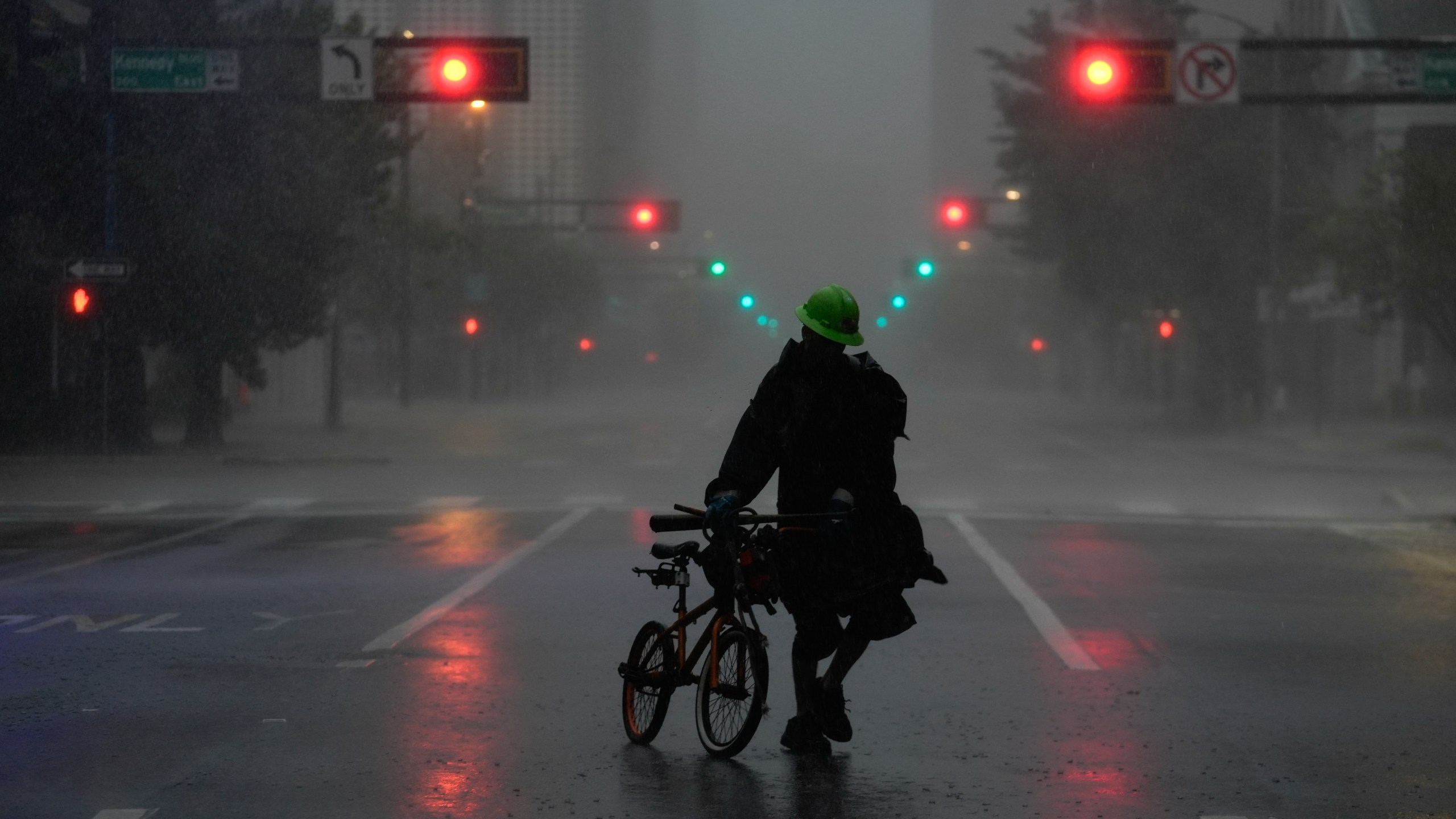 Ron Rook, who said he was looking for people in need of help or debris to clear, walks through windy and rainy conditions on a deserted street in downtown Tampa, Fla., during the approach of Hurricane Milton, Wednesday, Oct. 9, 2024. (AP Photo/Rebecca Blackwell)