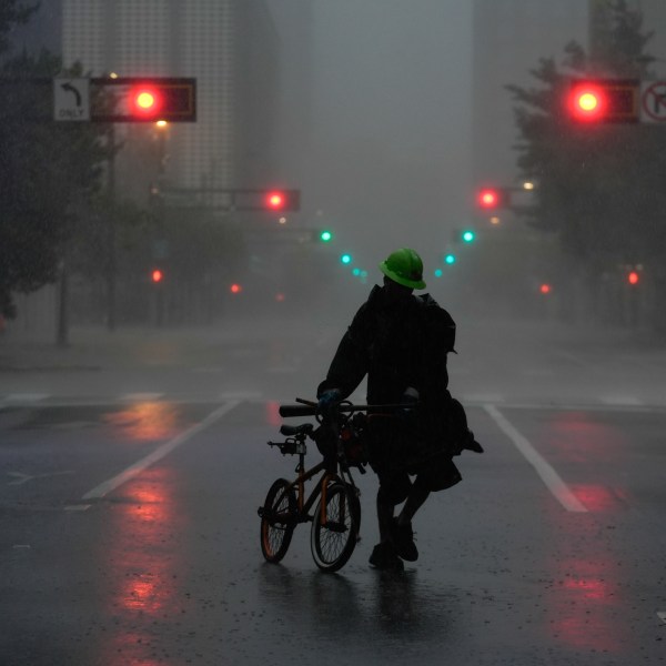 Ron Rook, who said he was looking for people in need of help or debris to clear, walks through windy and rainy conditions on a deserted street in downtown Tampa, Fla., during the approach of Hurricane Milton, Wednesday, Oct. 9, 2024. (AP Photo/Rebecca Blackwell)