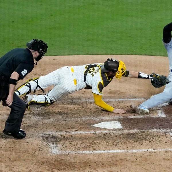 Los Angeles Dodgers' Shohei Ohtani, right, is tagged out at home plate by San Diego Padres catcher Kyle Higashioka after a single by Teoscar Hernández during the fourth inning in Game 4 of a baseball NL Division Series Wednesday, Oct. 9, 2024, in San Diego.(AP Photo/Ashley Landis)