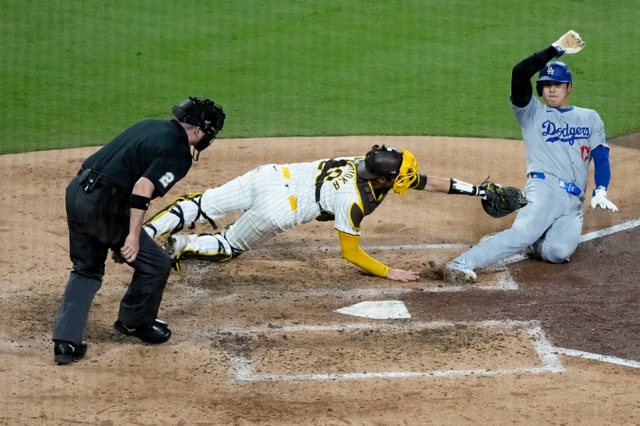 Los Angeles Dodgers' Shohei Ohtani, right, is tagged out at home plate by San Diego Padres catcher Kyle Higashioka after a single by Teoscar Hernández during the fourth inning in Game 4 of a baseball NL Division Series Wednesday, Oct. 9, 2024, in San Diego.(AP Photo/Ashley Landis)