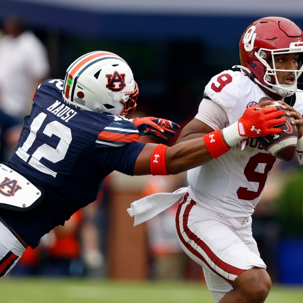 Oklahoma quarterback Michael Hawkins Jr. (9) escapes the pressure from Auburn linebacker Dorian Mausi Jr. (12) as he scrambles from the pocket during the first half of an NCAA college football game, Saturday, Sept. 28, 2024, in Auburn, Ala. (AP Photo/Butch Dill)