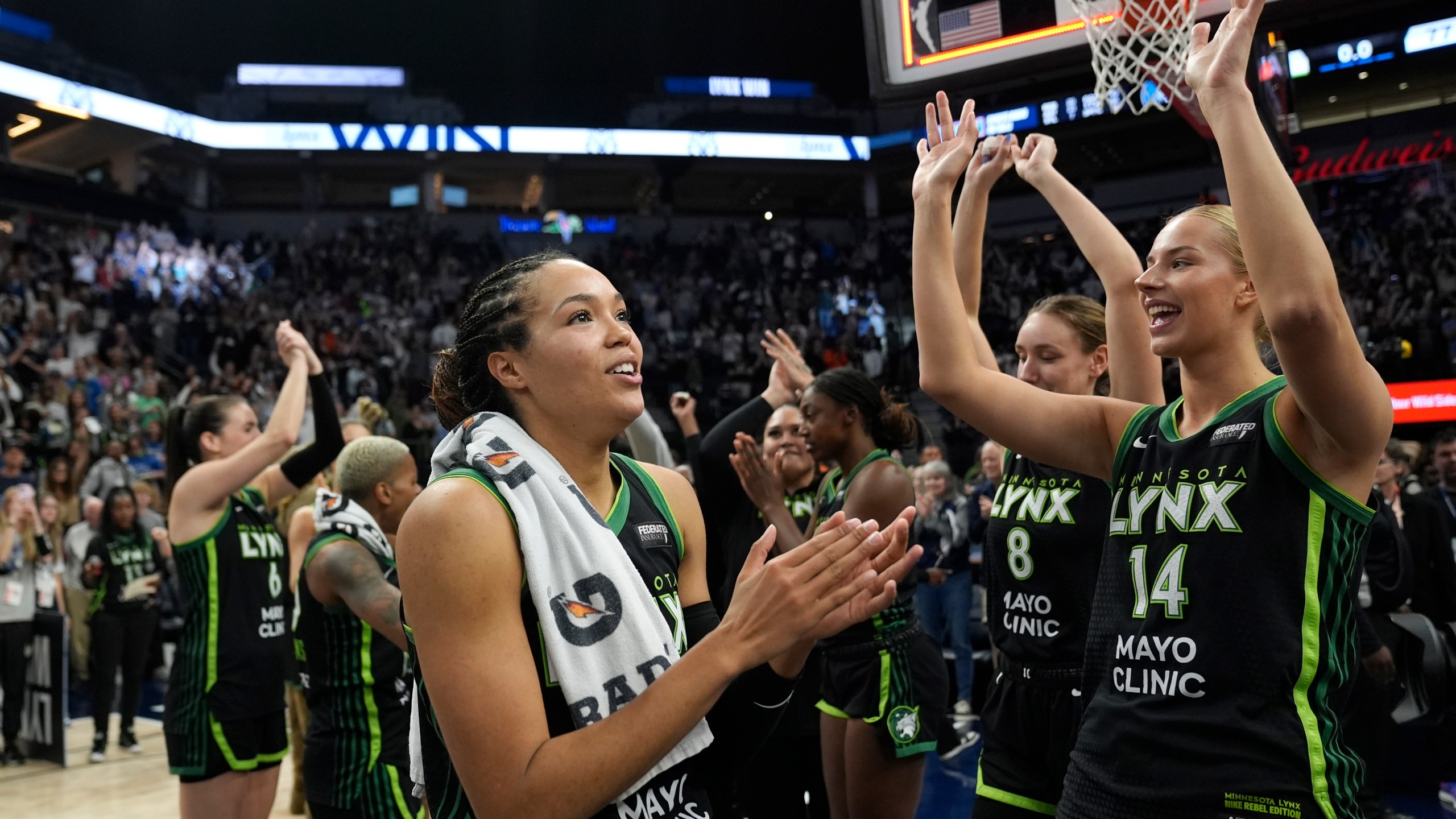 Minnesota Lynx forward Napheesa Collier, center, celebrates with teammates after the 88-77 win against the Connecticut Sun of Game 5 of a WNBA basketball semifinals, Tuesday, Oct. 8, 2024, in Minneapolis. (AP Photo/Abbie Parr)